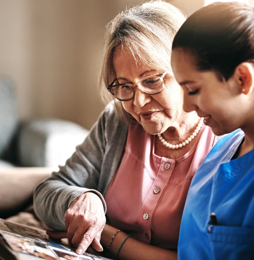 A woman and an elderly woman looking at a photo album